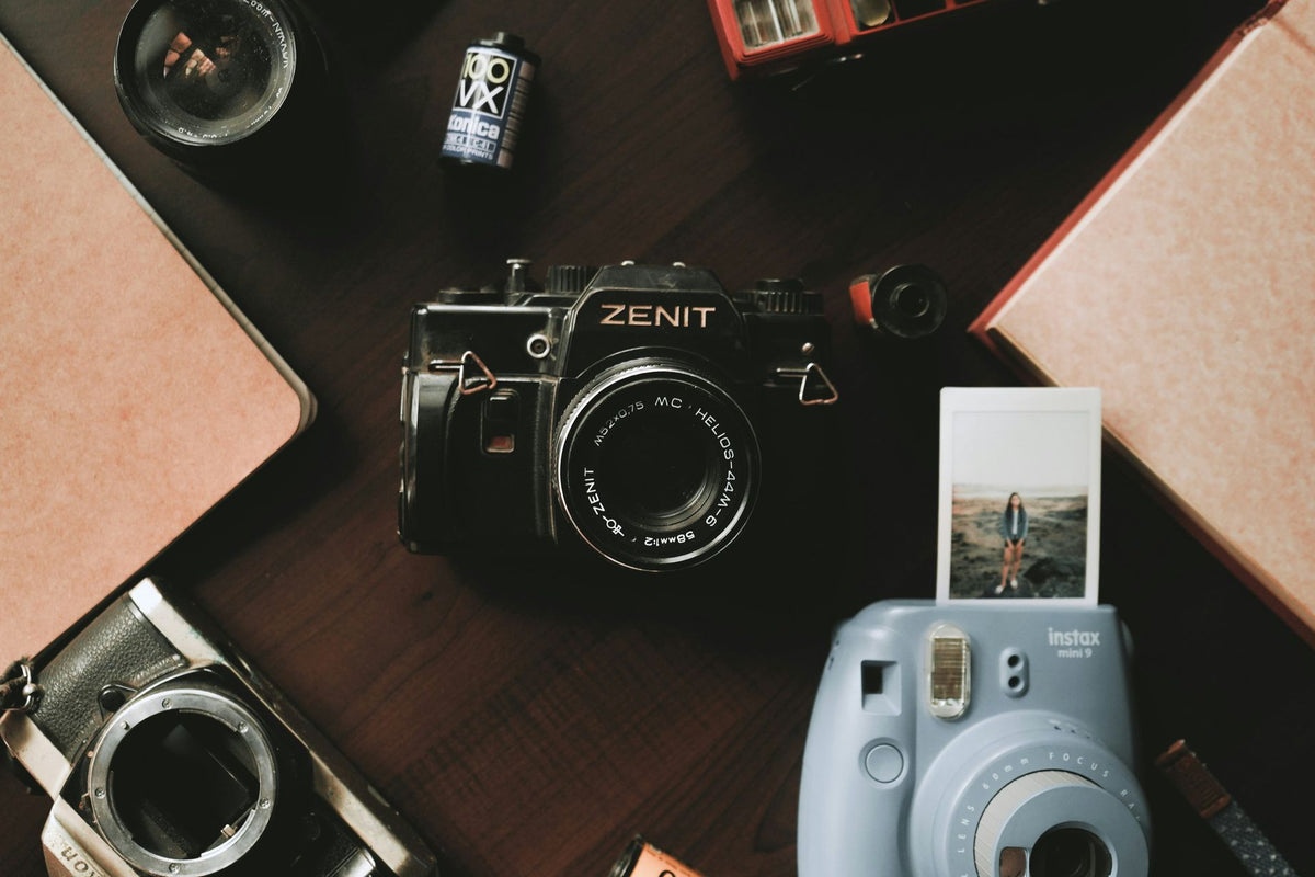 Zenit camera with Instax camera and instant photo on a wooden surface